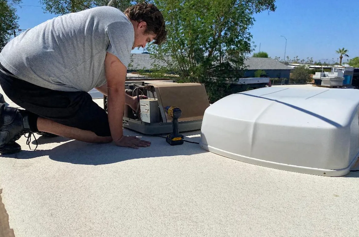 Mobile RV AC repair technician servicing a rooftop air conditioner in Stuart, Florida